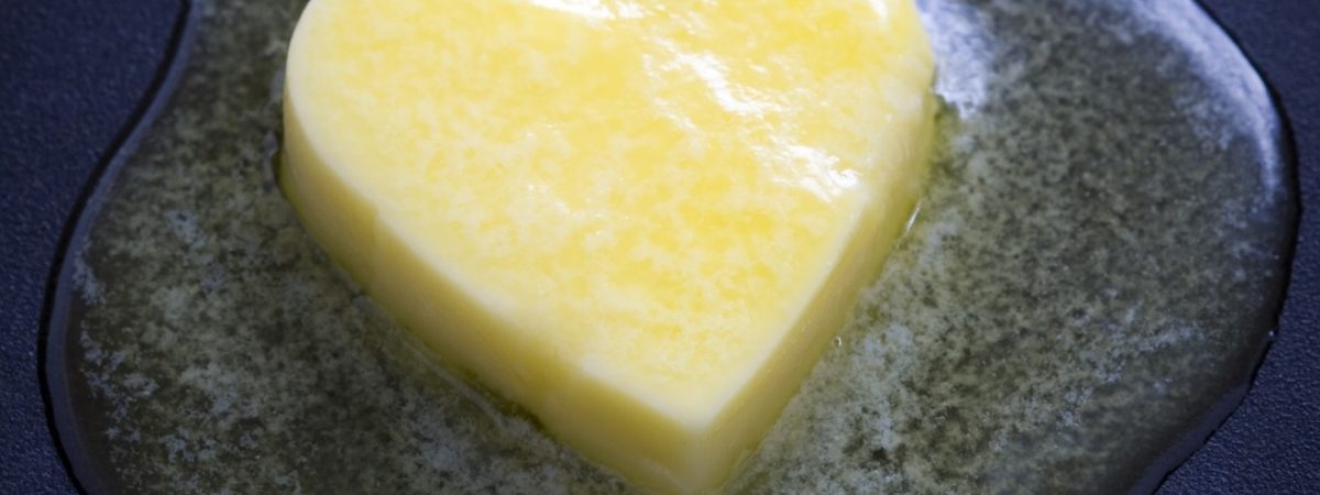 a heart shaped butter pat melting on a non-stick surface